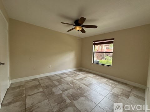 A room with a ceiling fan and a window.