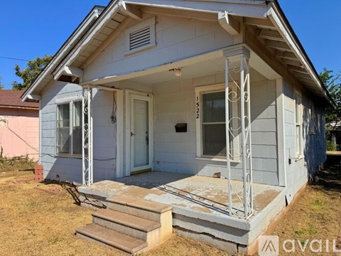 A small house with a porch and a white door.