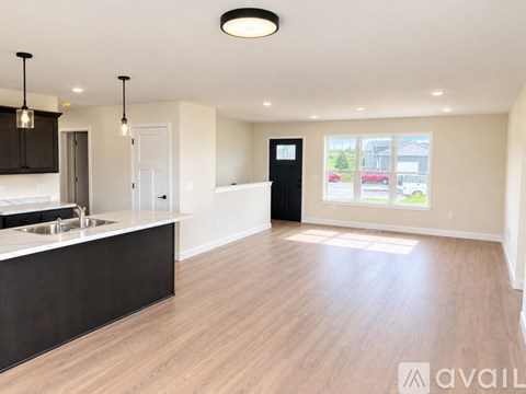A spacious kitchen with wooden floors and modern appliances.