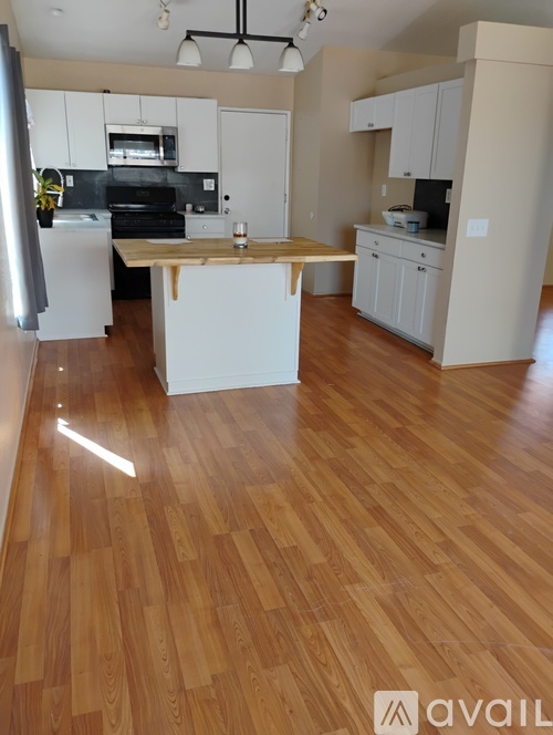 A kitchen with wooden floors and white cabinets.