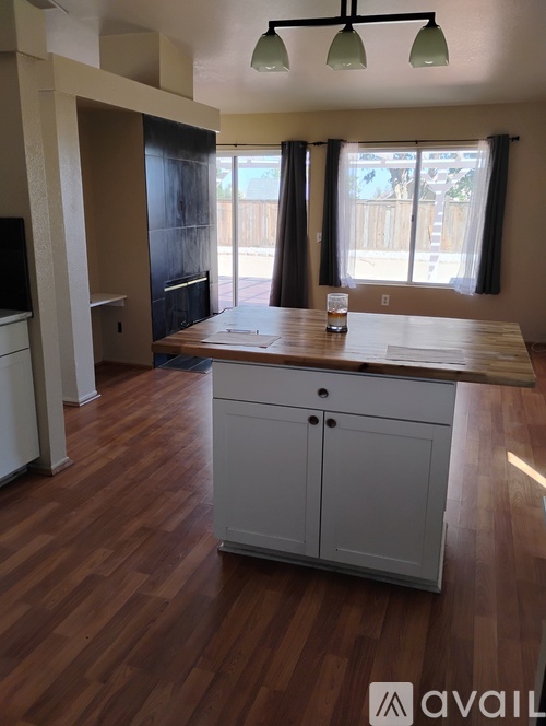 A kitchen with a wooden counter top and cabinets.