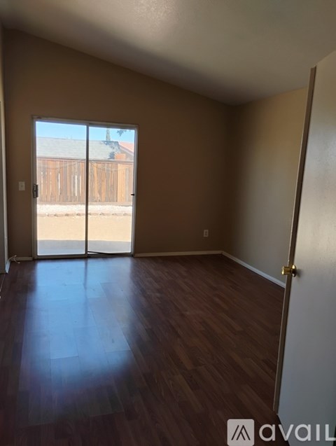 A room with wooden flooring and a sliding glass door.