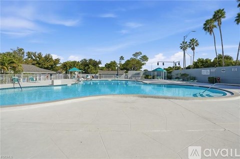 A large outdoor swimming pool surrounded by palm trees.