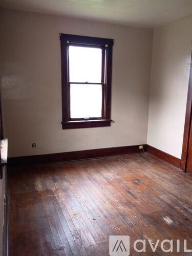 A room with a wooden floor and a window.