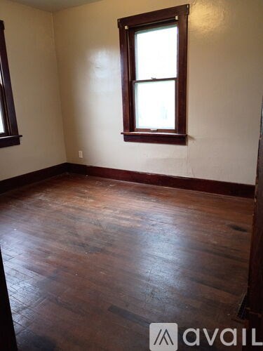 A room with wooden floors and a window.