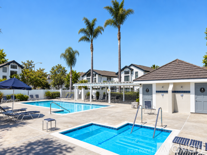 A swimming pool with a diving board and a small pavilion.