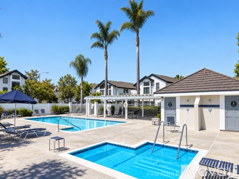 A swimming pool with a diving board and a small pavilion.