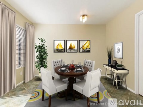 A dining room with a table set for four and a potted plant.