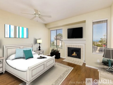 A bedroom with a large bed, a fireplace, and a television.