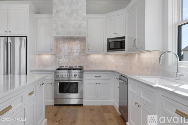 A kitchen with white cabinets and a tiled backsplash.