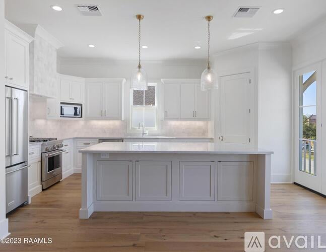 A modern kitchen with white cabinets and a central island.
