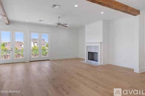 A spacious room with a fireplace and a ceiling fan.