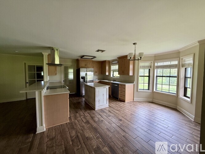 A kitchen with wood flooring and a large island.