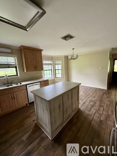 A kitchen with wooden cabinets and a large island.