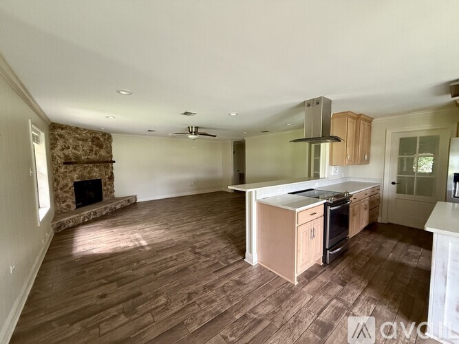 A kitchen with wooden floors and a fireplace.