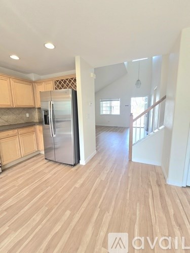 A kitchen with wooden floors and a refrigerator.