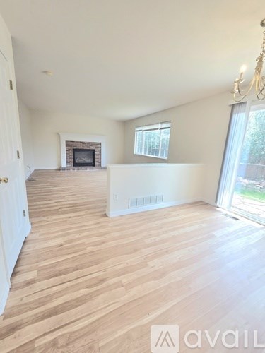 A living room with a fireplace and wooden flooring.