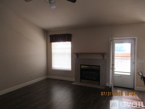A room with a fireplace and a window with blinds.