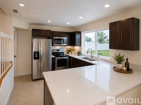 A modern kitchen with dark brown cabinets and stainless steel appliances.
