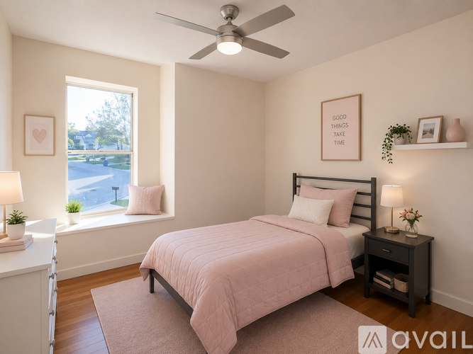 A bedroom with a pink bedspread and a bed with a black headboard.