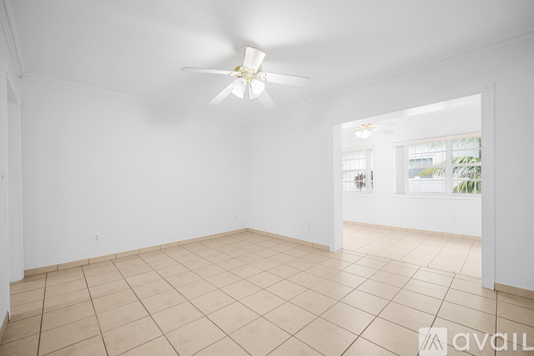 A spacious room with a ceiling fan and tiled flooring.