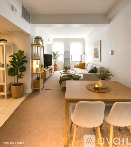 A living room with a wooden table and white chairs.