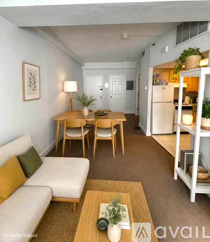 A living room with a white couch, a wooden coffee table, and a white refrigerator.
