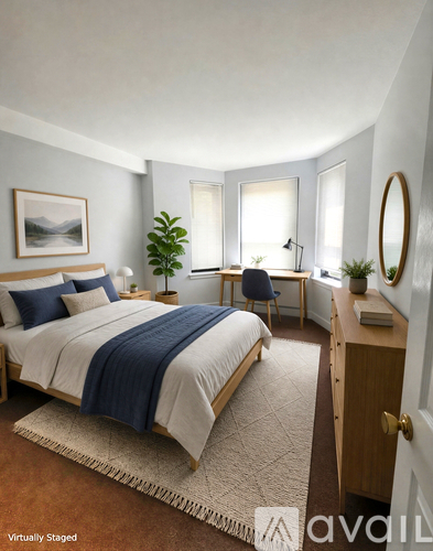 A bedroom with a bed, desk, chair, and a painting on the wall.
