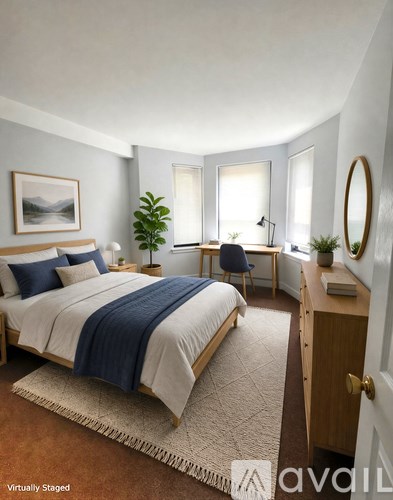 A bedroom with a bed, desk, chair, and a painting on the wall.