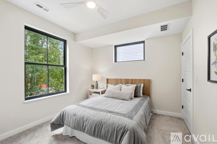 A bedroom with a large bed and a window overlooking a green area.