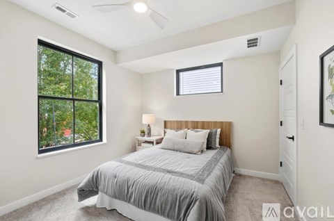 A bedroom with a large bed and a window overlooking a green area.
