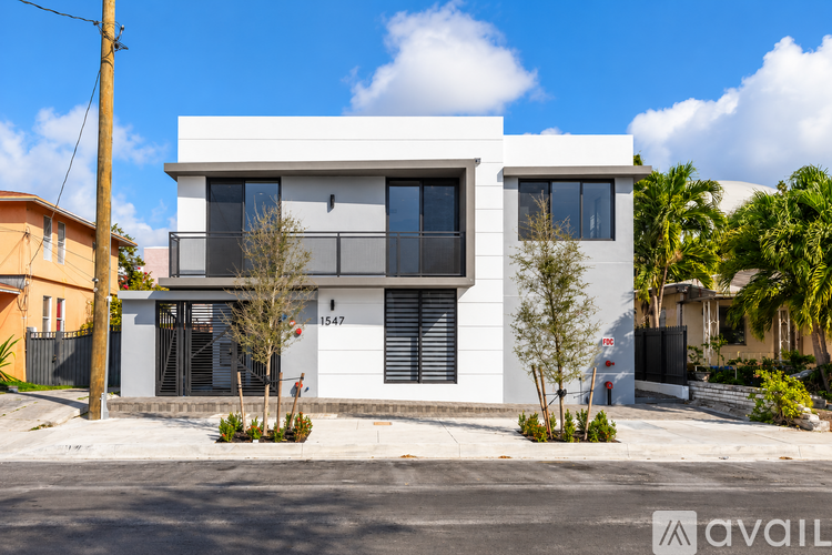 A modern two-story house with a white exterior and black shutters.