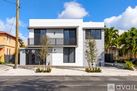 A modern two-story house with a white exterior and black shutters.