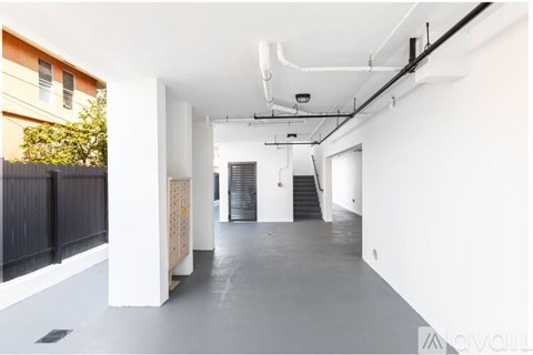 A long, empty hallway with white walls and a concrete floor.