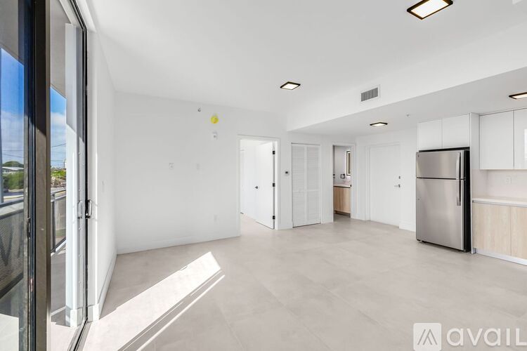 A spacious kitchen with white cabinets and a stainless steel refrigerator.