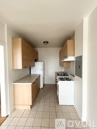 A kitchen with white appliances and wooden cabinets.