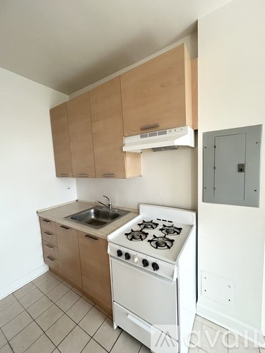 A kitchen with a white stove and wooden cabinets.