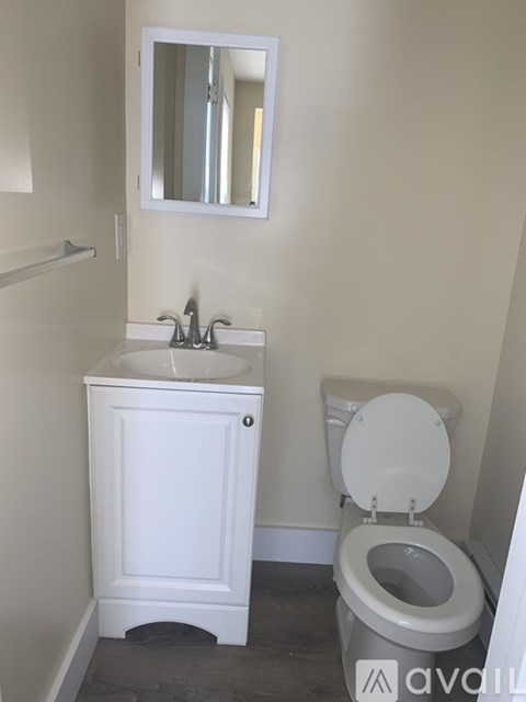 A white toilet with a sink and mirror in a bathroom.