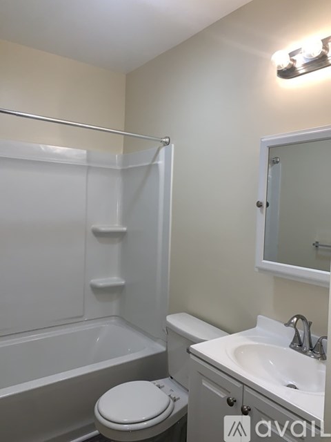 A white toilet sits next to a bathtub in a bathroom.