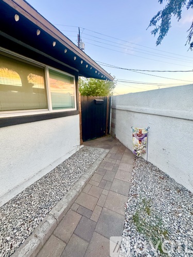 A small patio area with a black door and a wall with a colorful mural.