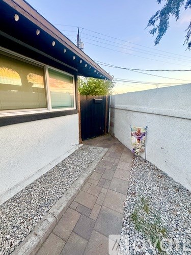 A small patio area with a black door and a wall with a colorful mural.
