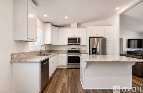 A modern kitchen with white cabinets and stainless steel appliances.