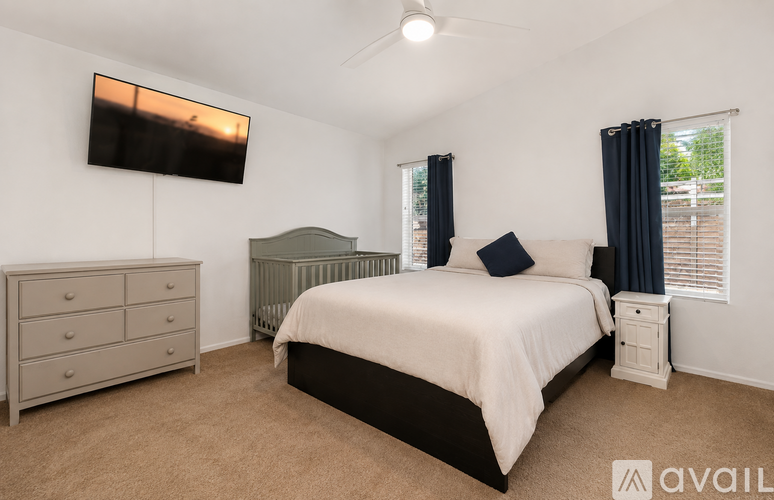 A bedroom with a bed, dresser, and television.