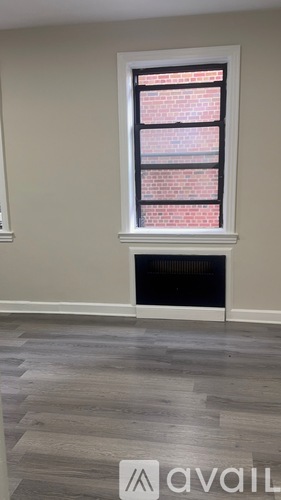 A room with a fireplace and a window with a brick pattern.