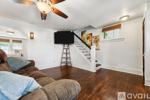 A living room with a brown couch and a white wall.