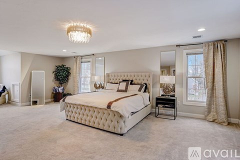 A large bedroom with a large bed and a chandelier.