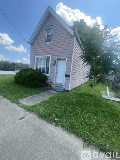A house with a white door and a small front yard.
