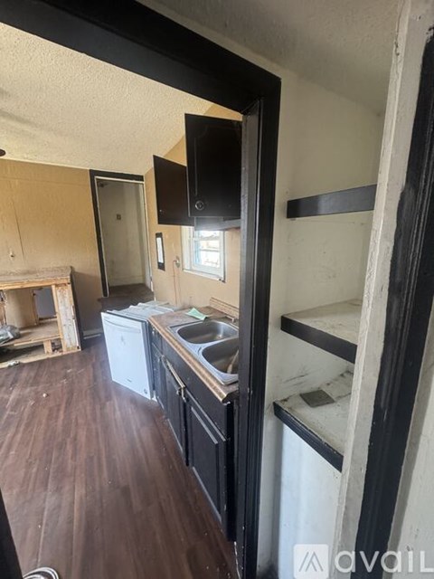 A kitchen area with a sink and a refrigerator.