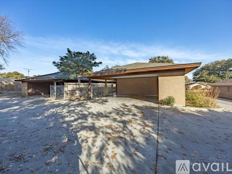 A two-car garage with a brown roof and a tree in the background.