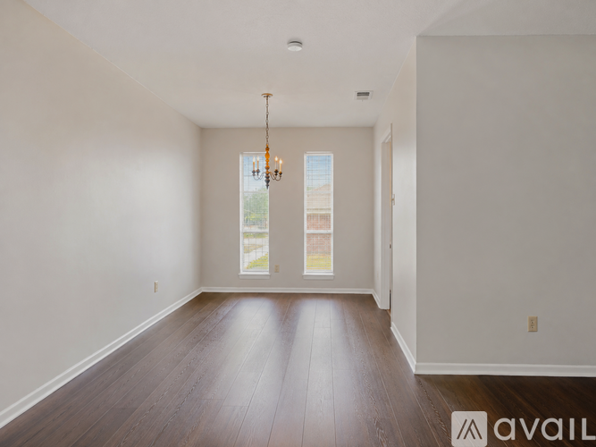 A room with wooden floors and a chandelier.